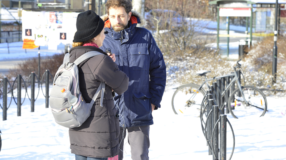 En man intervjuar en kvinna med ryggsäck.